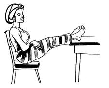 Une femme assise les pieds sur une table. Ses pieds ont l’air normal, pas enflés.