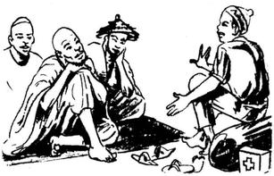 Un agent de santé est assis par terre et discute avec trois anciens du village.